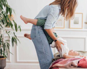 A woman is holding the leg of a child