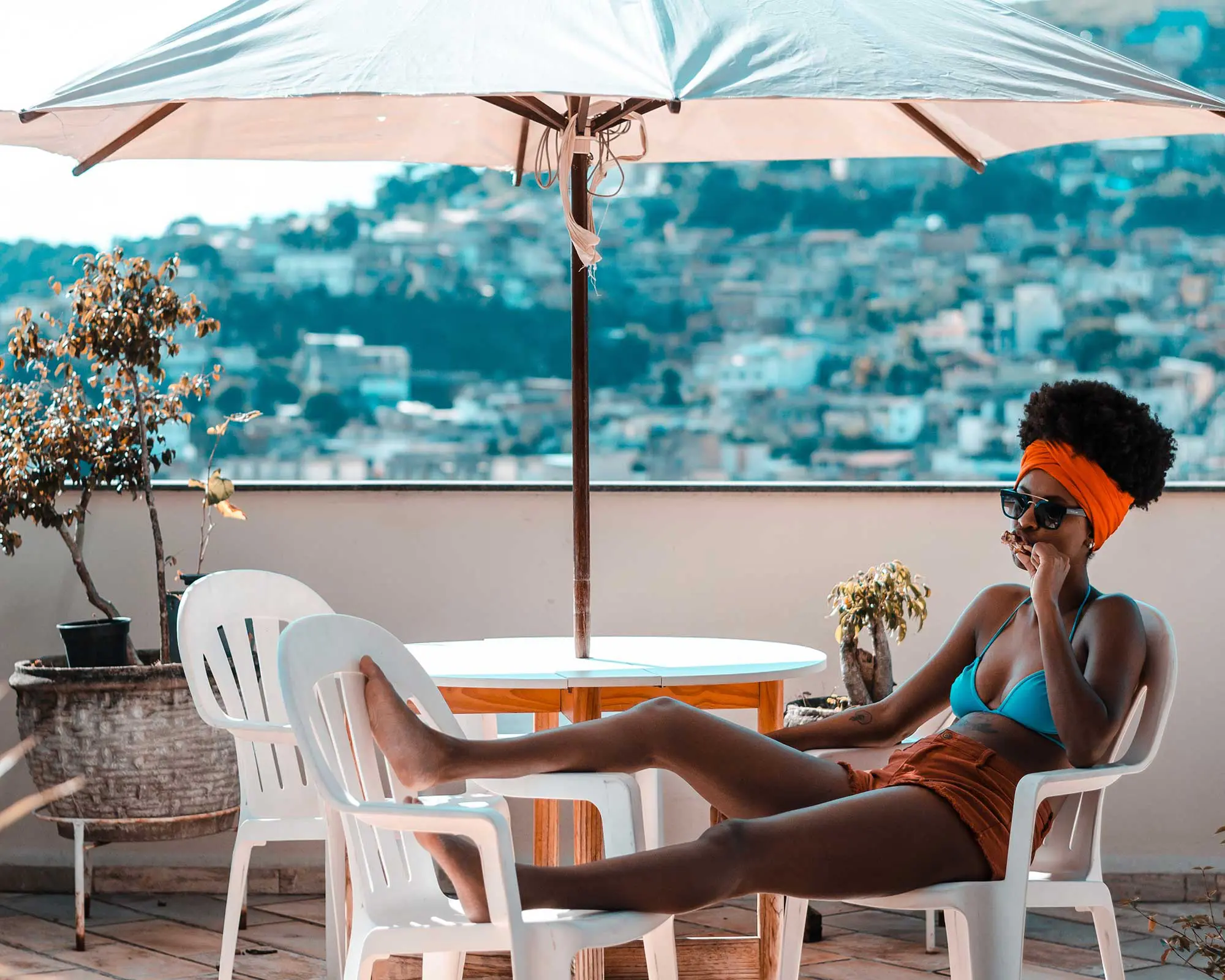 A woman sitting on top of an umbrella.