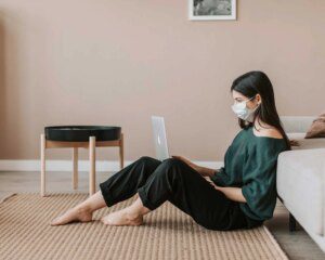 A woman sitting on the floor with her laptop.