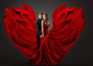 A man and woman in red dress posing for the camera.