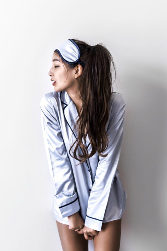 A woman in pajamas leaning against the wall.