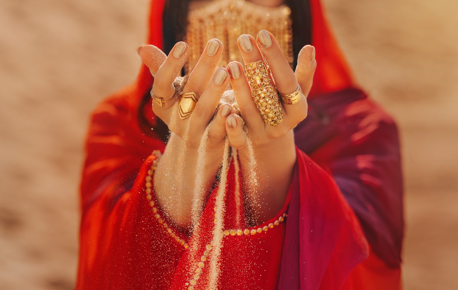 A woman in red dress holding her hands up.