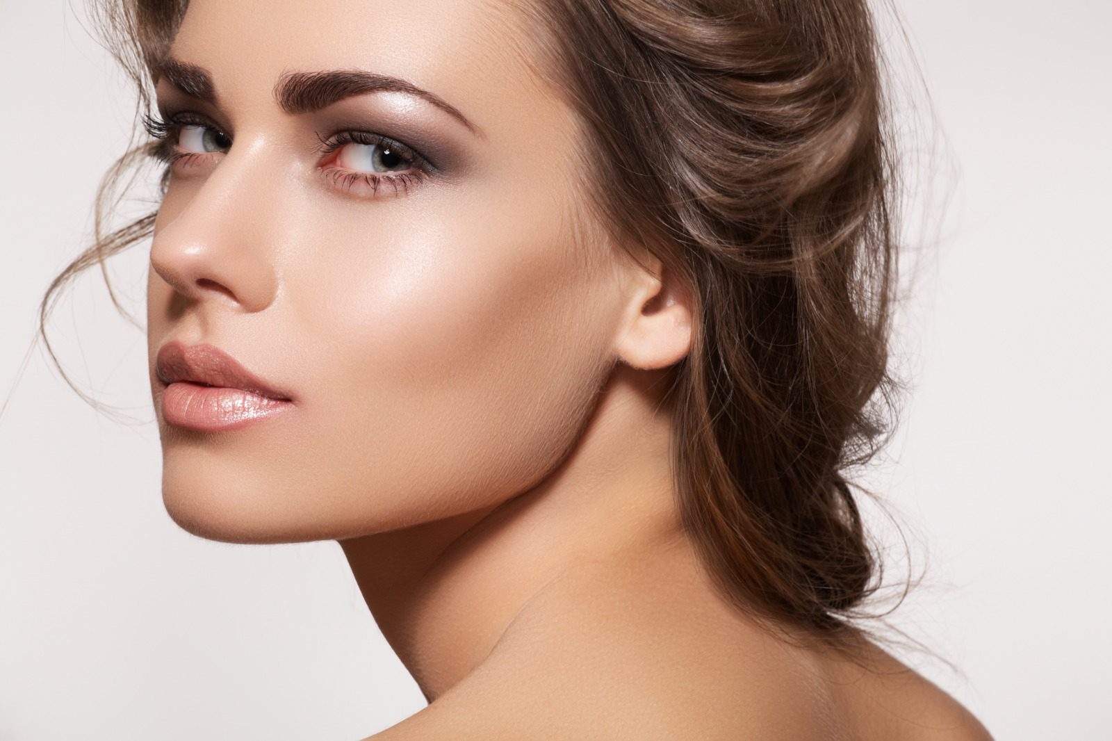 A woman with brown hair and a bare shoulder.