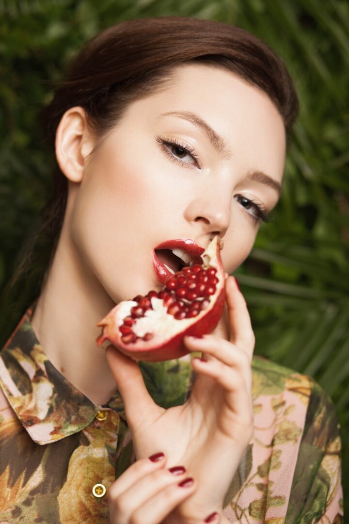 A woman holding a piece of fruit in her hand.