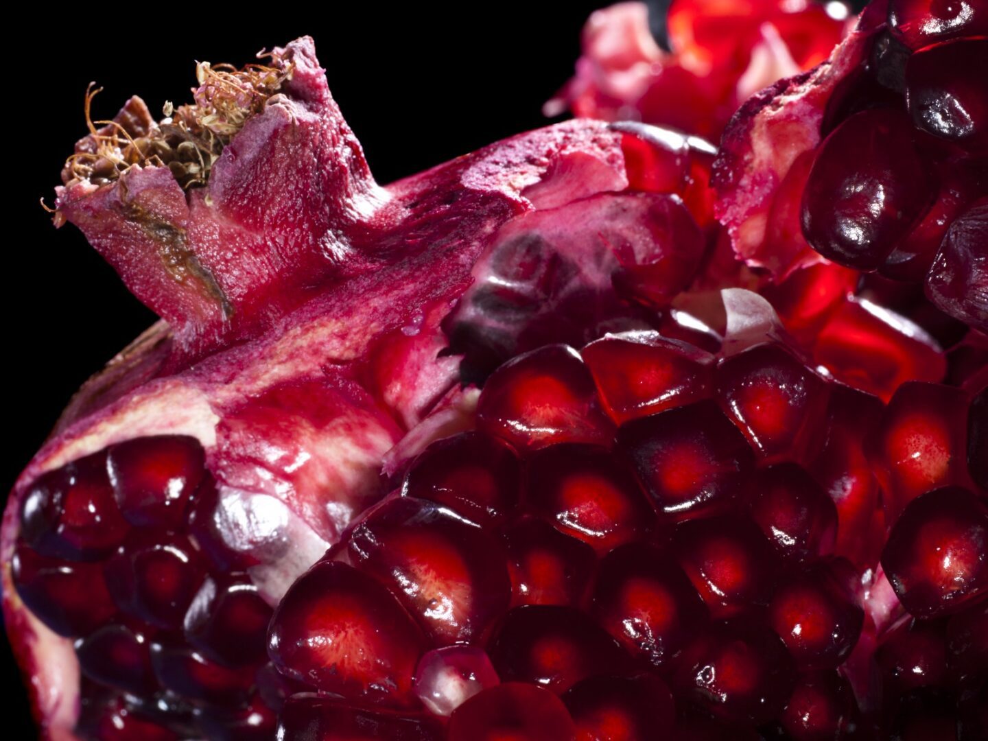 A close up of the inside of an open pomegranate.