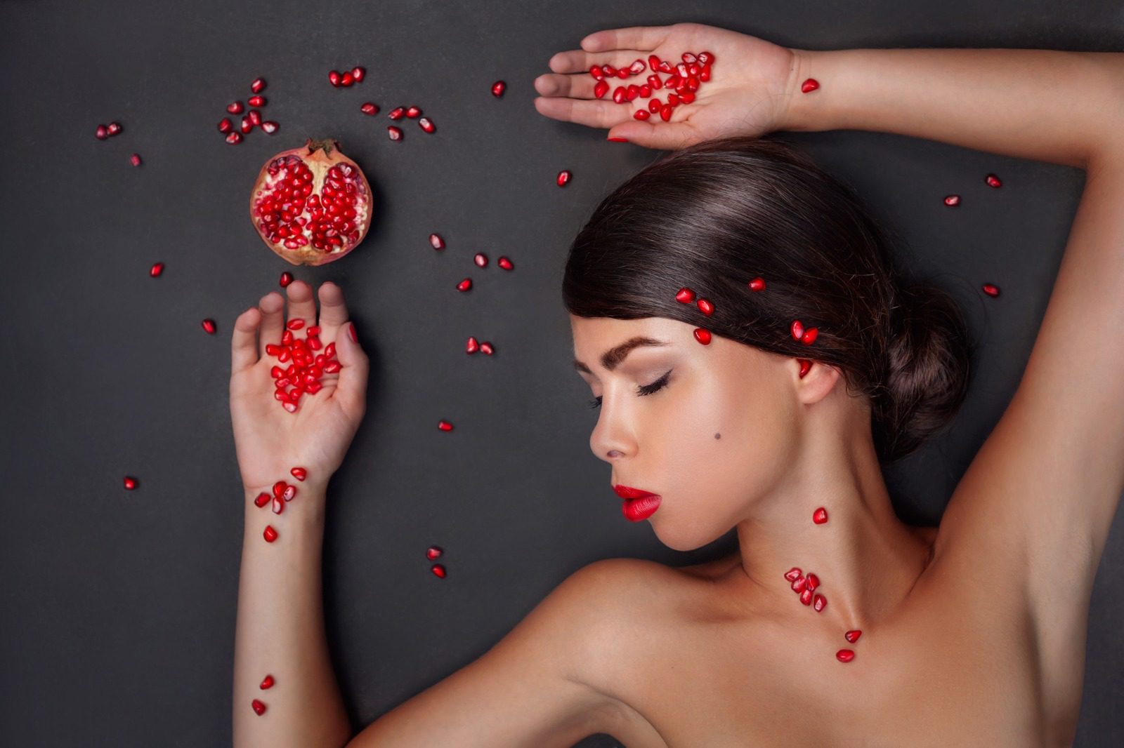 A woman holding pomegranates in her hands.