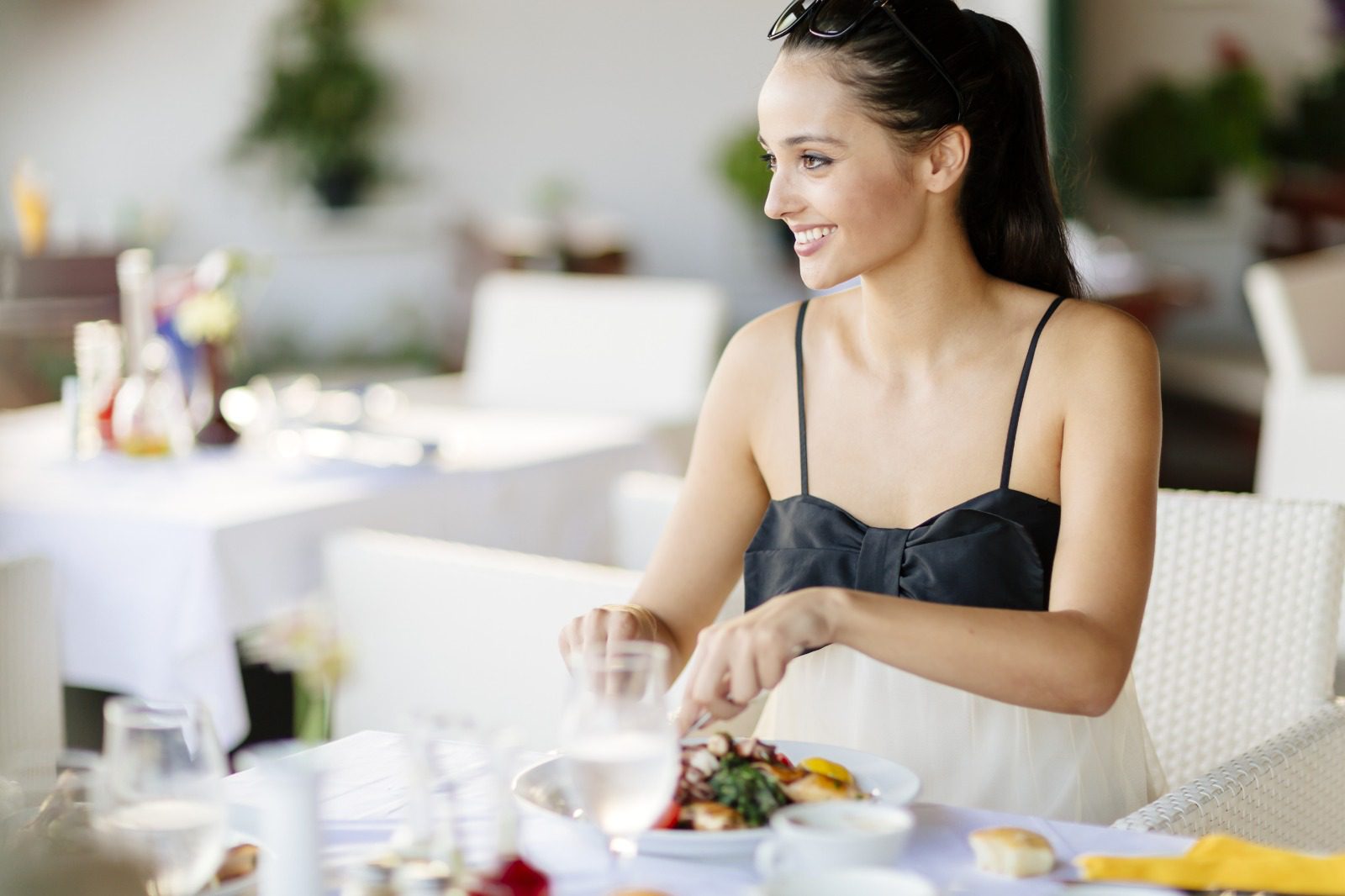 A woman sitting at the table with food in front of her.