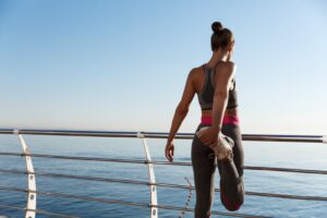 A woman standing on the side of a pier near water.