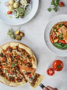 A pizza and salad are on the table.