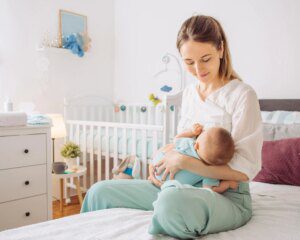 A woman holding her baby in the arms of another person.