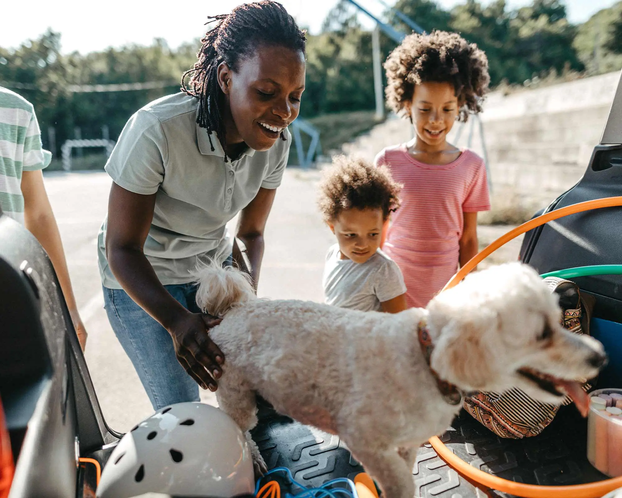 A woman and two children petting a dog.