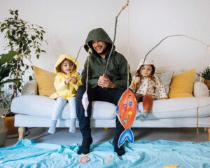 A man and two children sitting on the couch