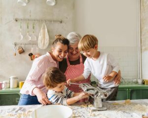 A group of people in the kitchen making food.