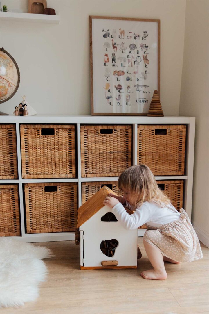 A little girl sitting on top of a wooden house.