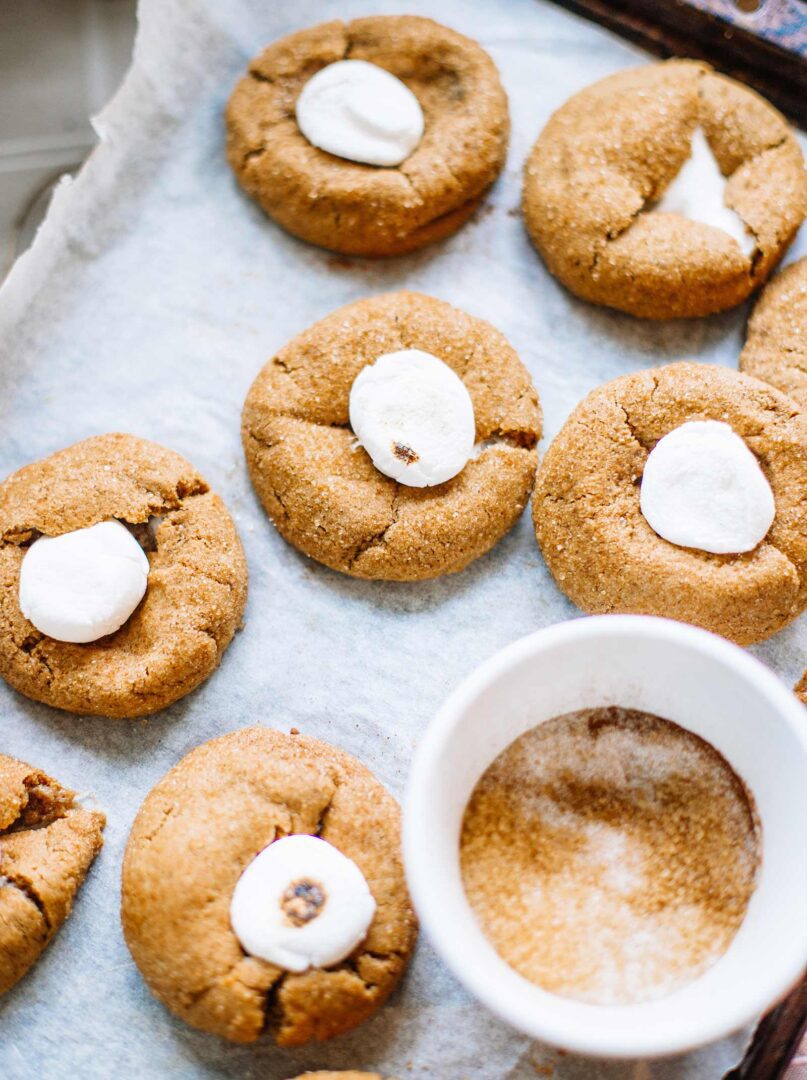 A white bowl of cookies on top of a table.