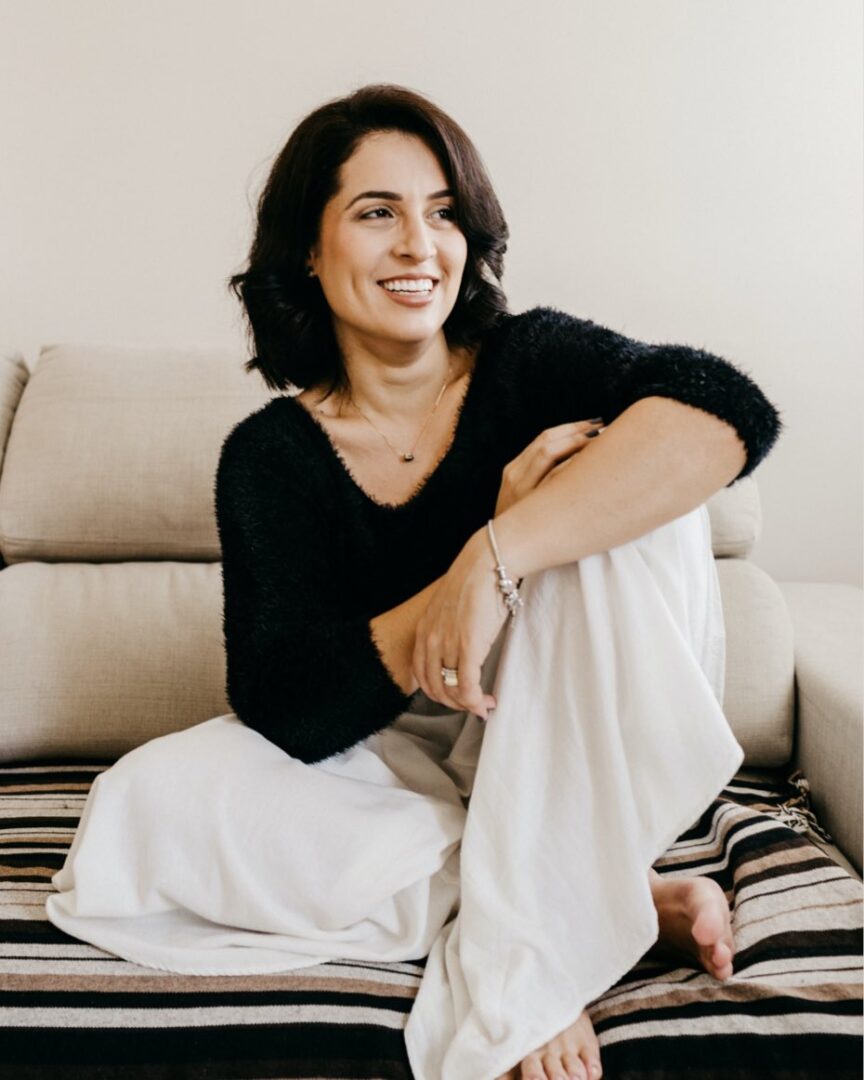 A woman sitting on top of a couch in her living room.