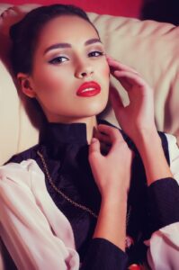 A woman with red lipstick and a necklace.