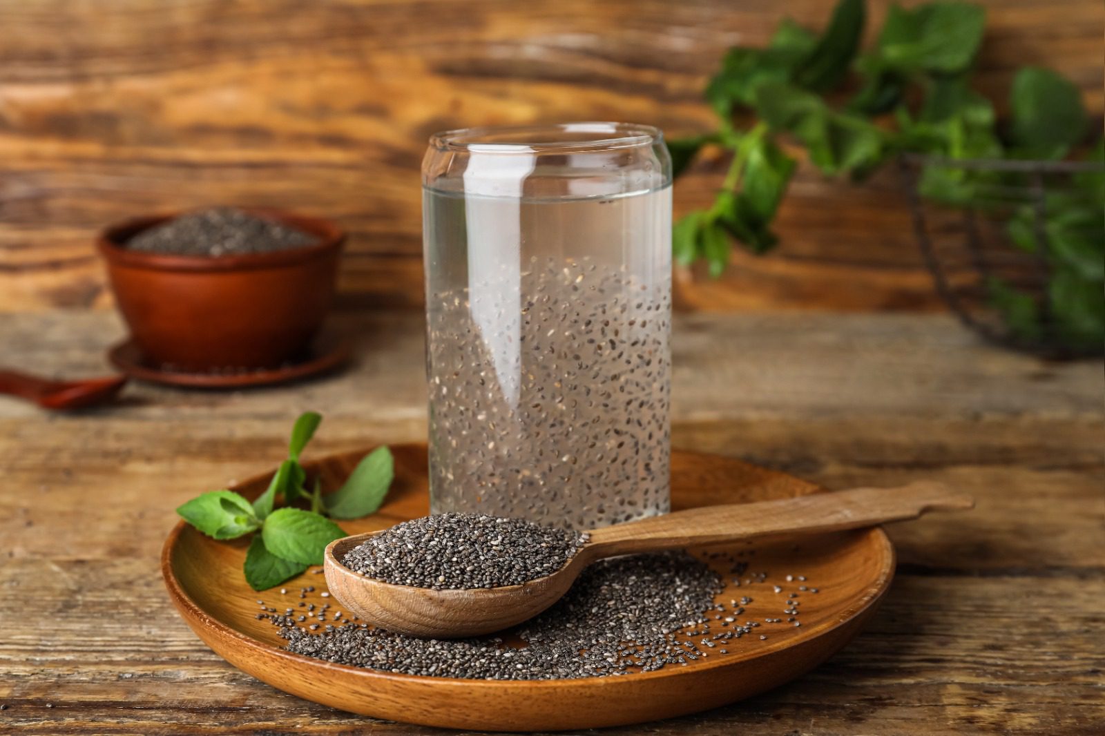 A wooden spoon and bowl with chia seeds on it.