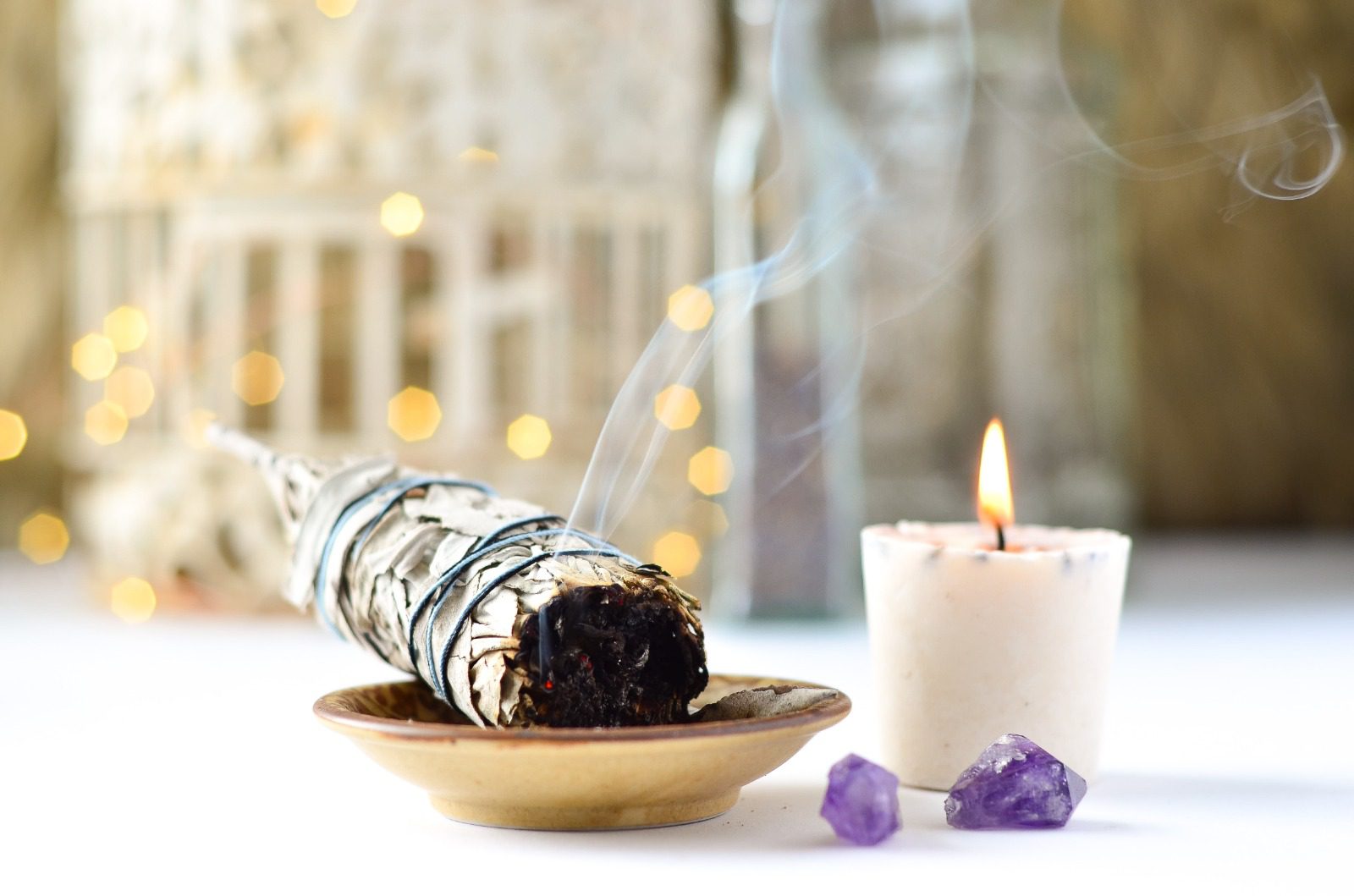 A candle and some smoke in a bowl