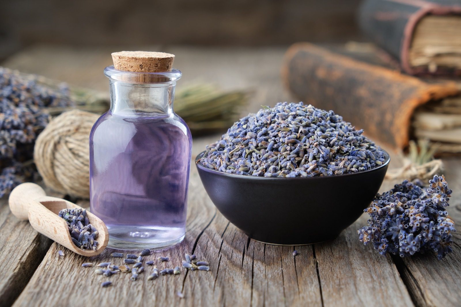 A bowl of lavender and a bottle of lavender oil.