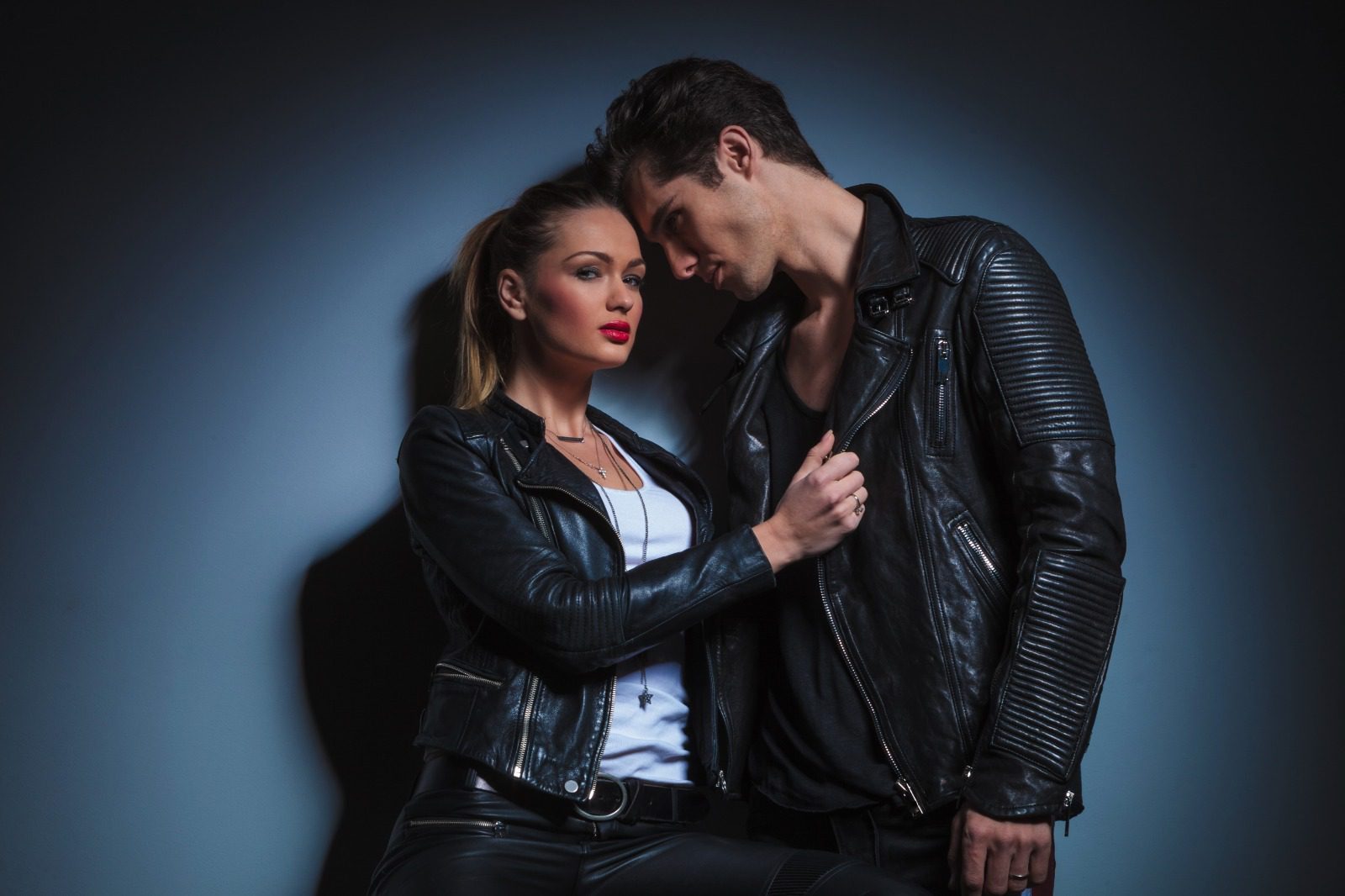 A man and woman in leather jackets posing for the camera.