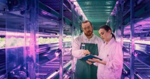 Two people in a factory looking at something on a tablet.