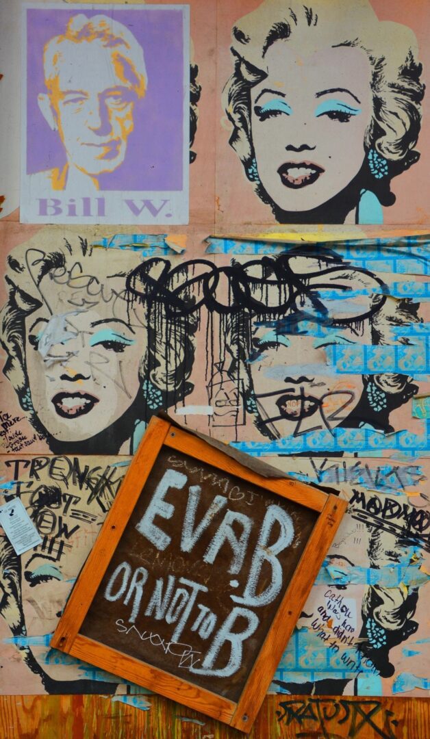 A wall covered in graffiti and stickers with marilyn monroe on it.